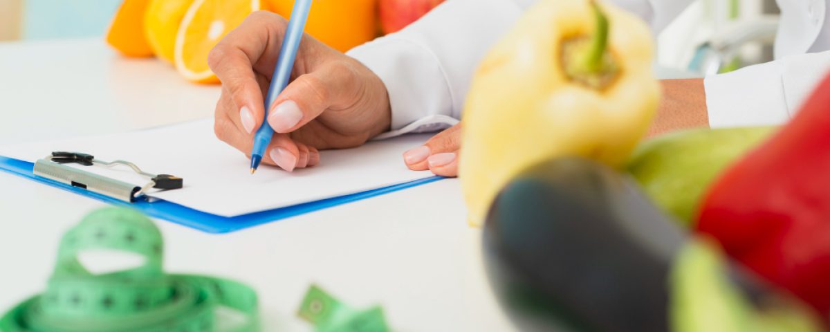 close-up-nutritionist-writing-prescription